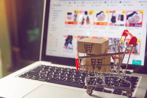 E-commerce online concept - Parcel or Paper cartons with a shopping cart logo in a trolley on a laptop keyboard. Shopping service on The online web. offers home delivery.