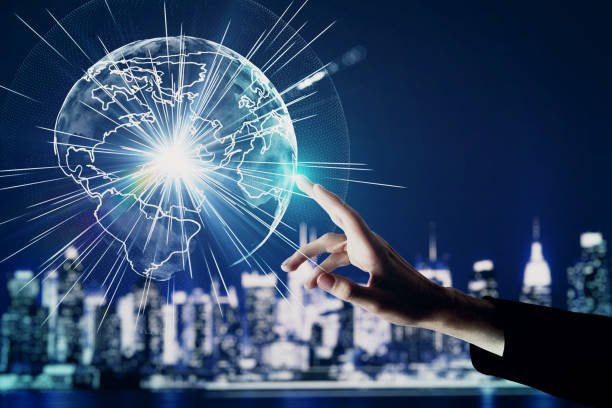 Hand pointing at abstract glowing globe on blurry night For digital work in France